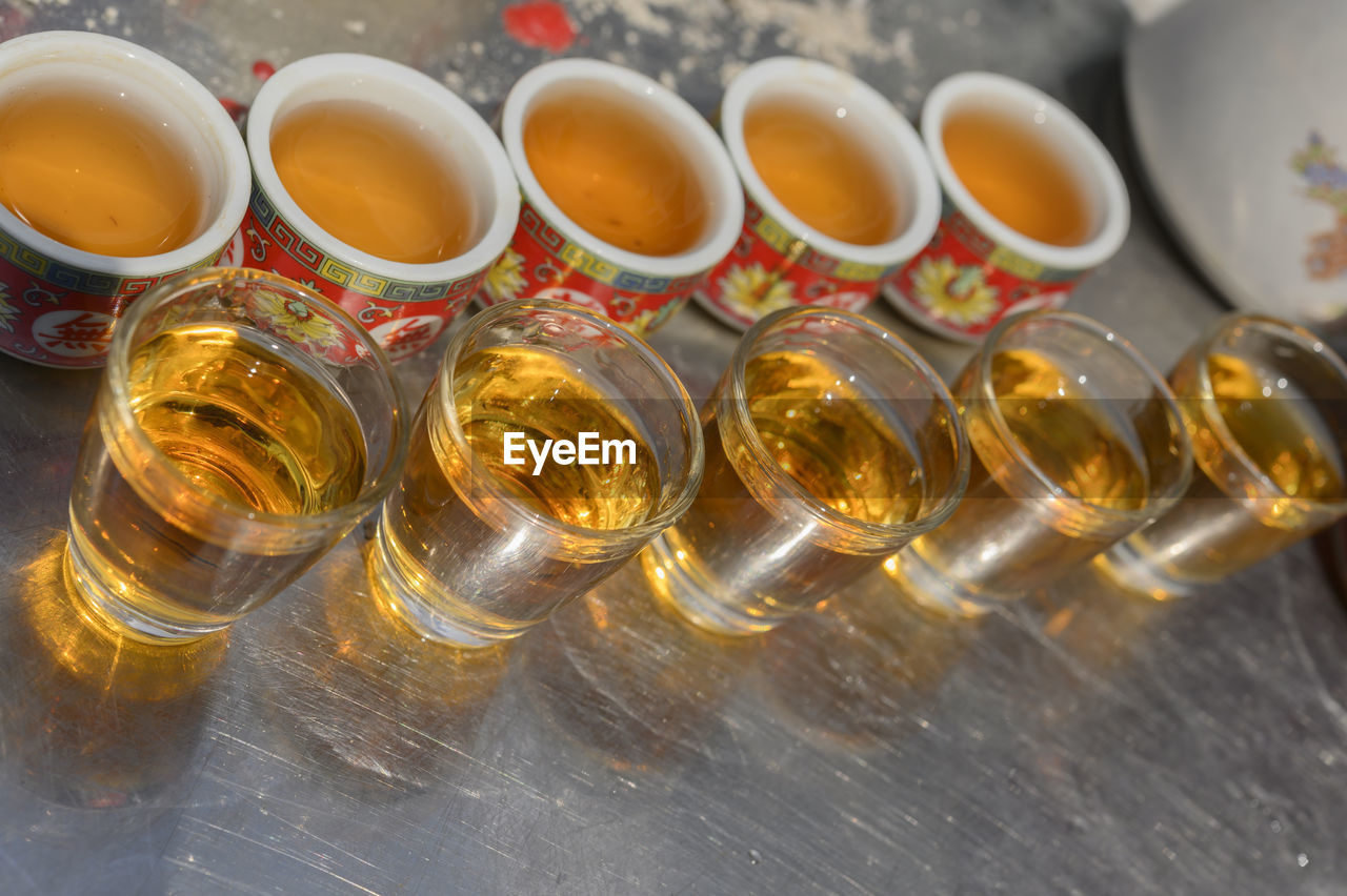 HIGH ANGLE VIEW OF GLASSES OF BOTTLES ON TABLE