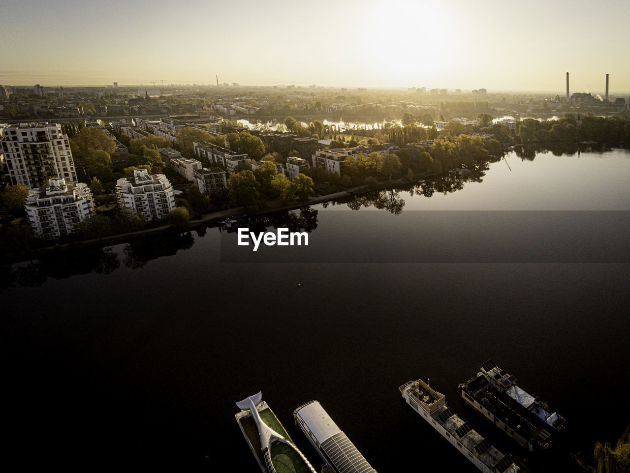 HIGH ANGLE VIEW OF RIVER AMIDST BUILDINGS AGAINST SKY