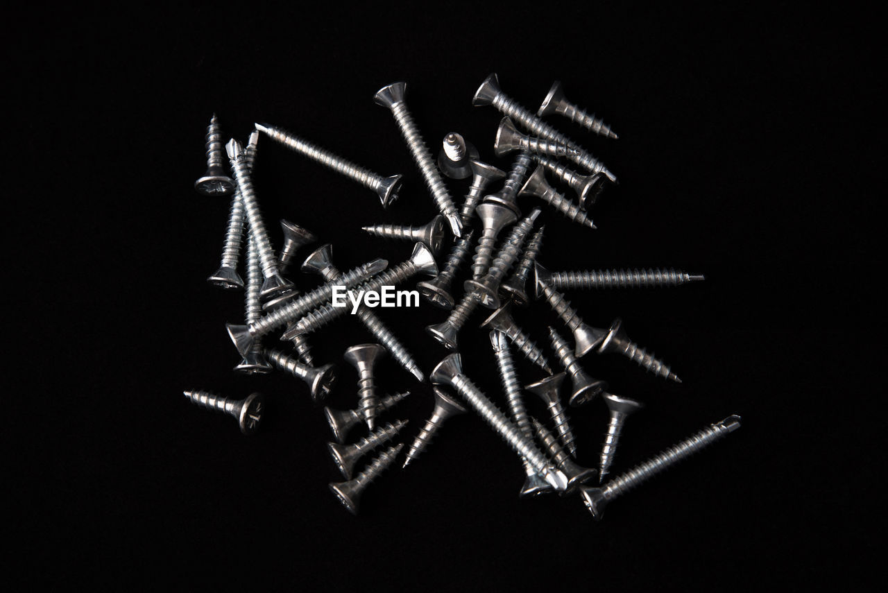 High angle view of screws against black background