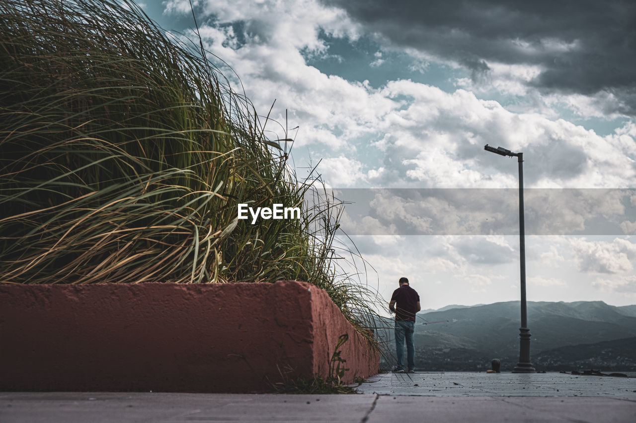 Full length of man standing on road against sky