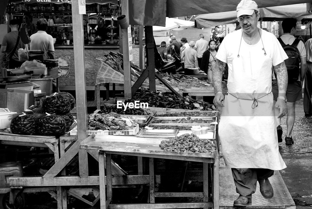 PEOPLE IN MARKET STALL