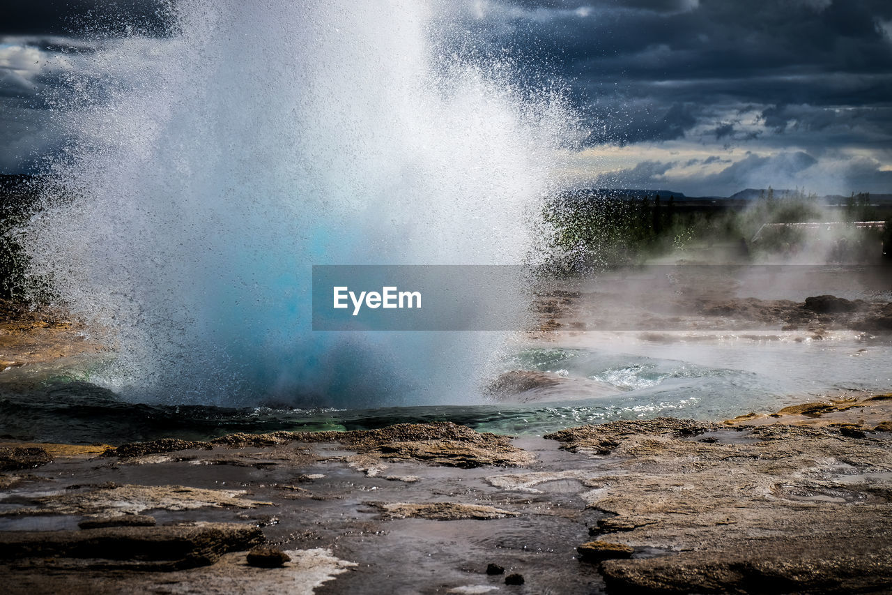 Scenic view of geyser erupting