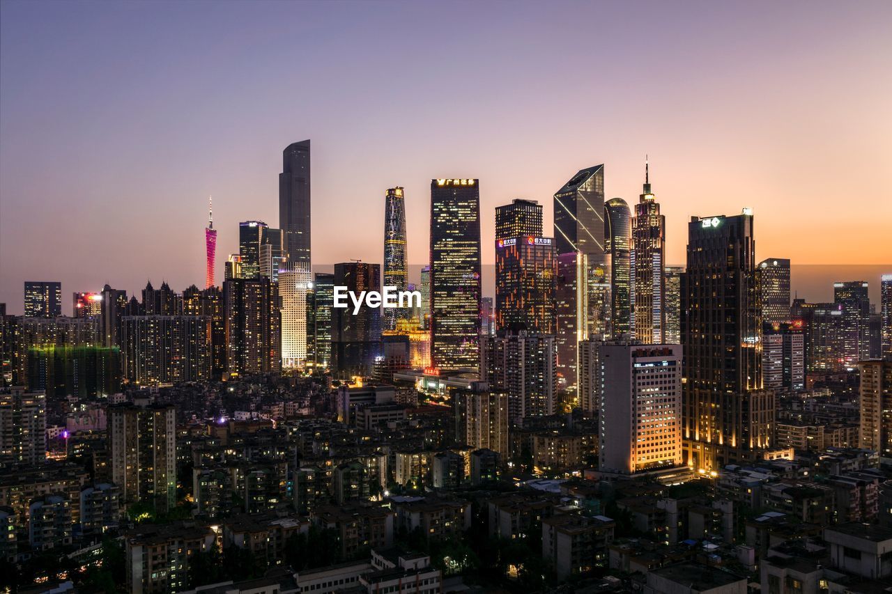 Aerial view of illuminated buildings in city against sky