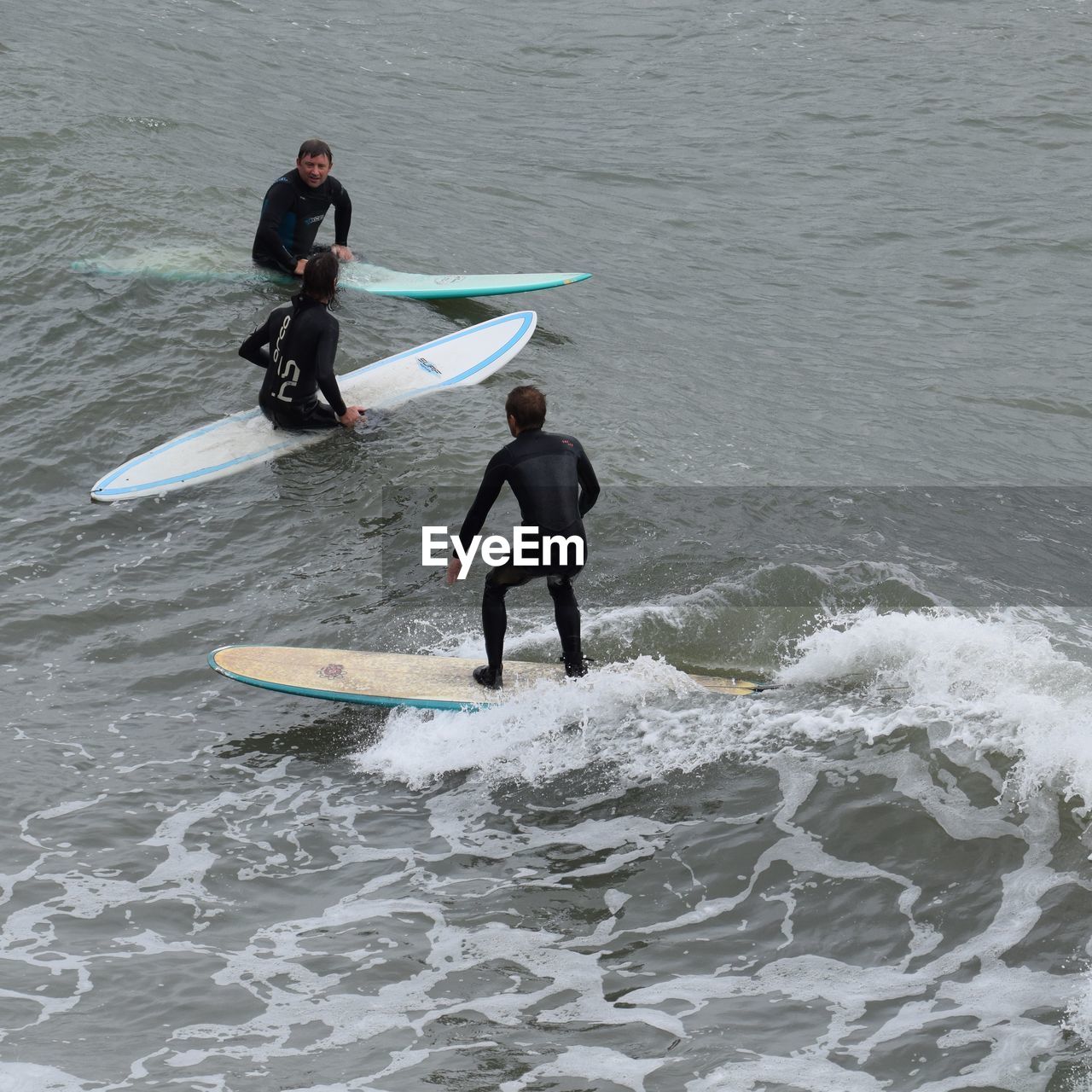 FULL LENGTH OF MEN IN SEA AGAINST SKY