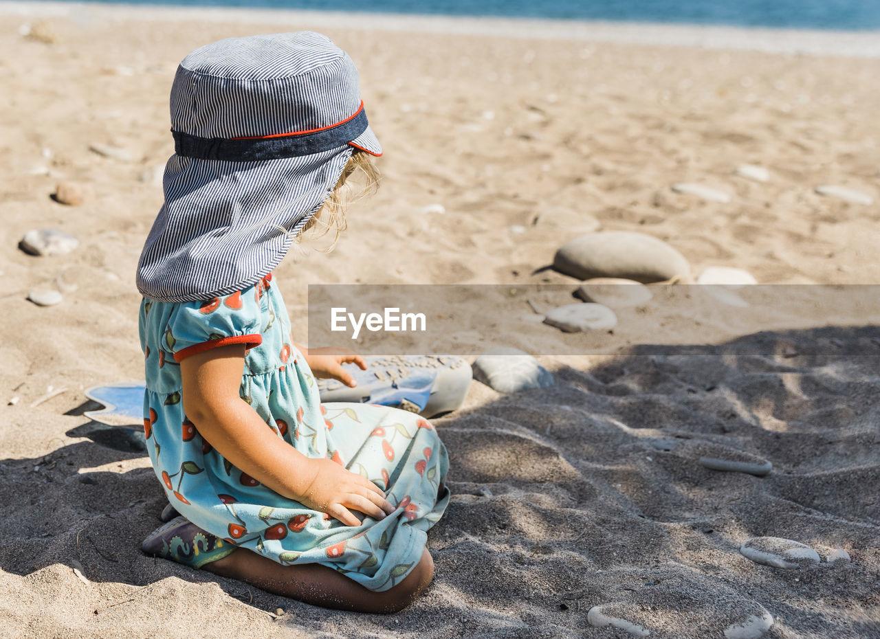 BOY SITTING ON BEACH
