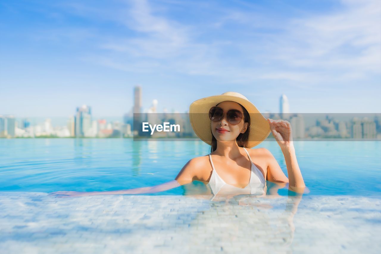 PORTRAIT OF YOUNG WOMAN IN SWIMMING POOL