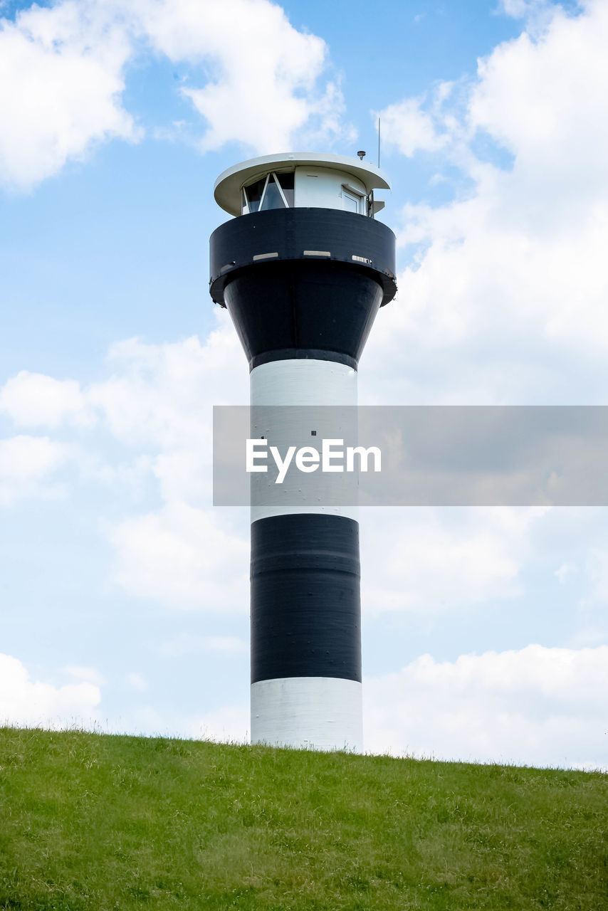 Low angle view of lighthouse on field against sky