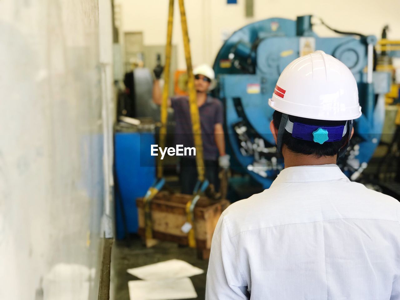 Rear view of young man working in factory