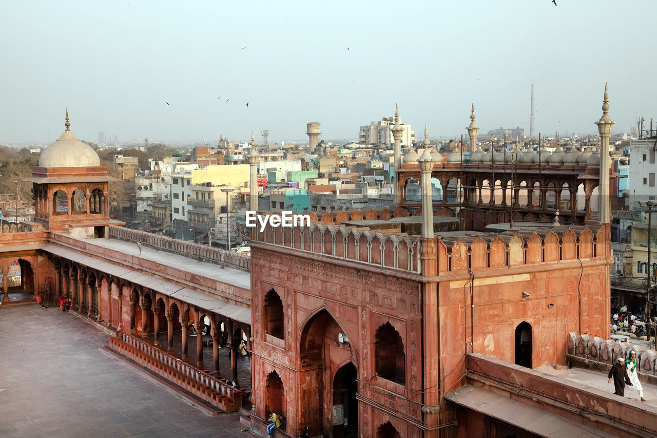 Jama masjid by cityscape against clear sky