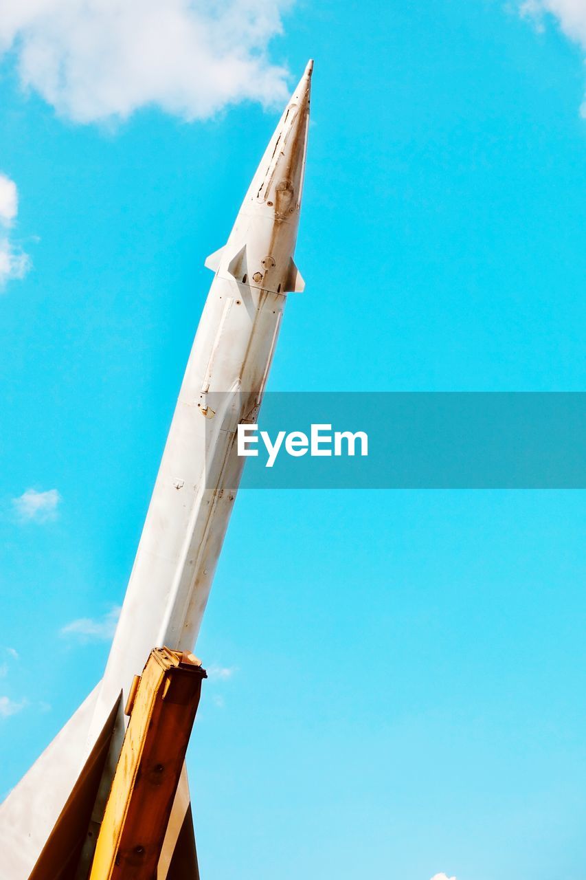 Low angle view of rocket against blue sky