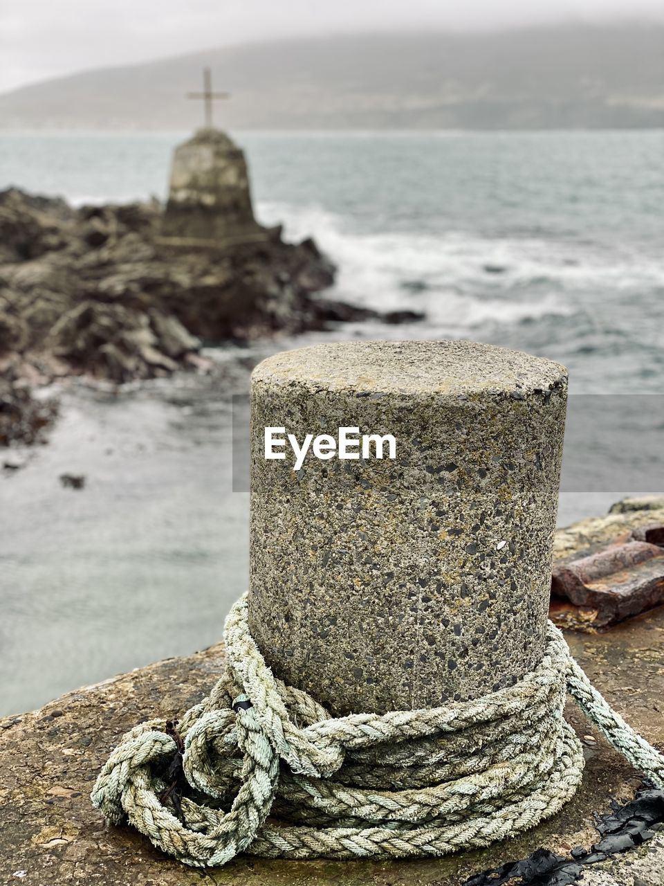 water, sea, beach, land, rock, rope, coast, nature, sand, no people, focus on foreground, shore, day, outdoors, sky, nautical vessel, harbor, post, strength, tied up, bollard, transportation, close-up, ocean