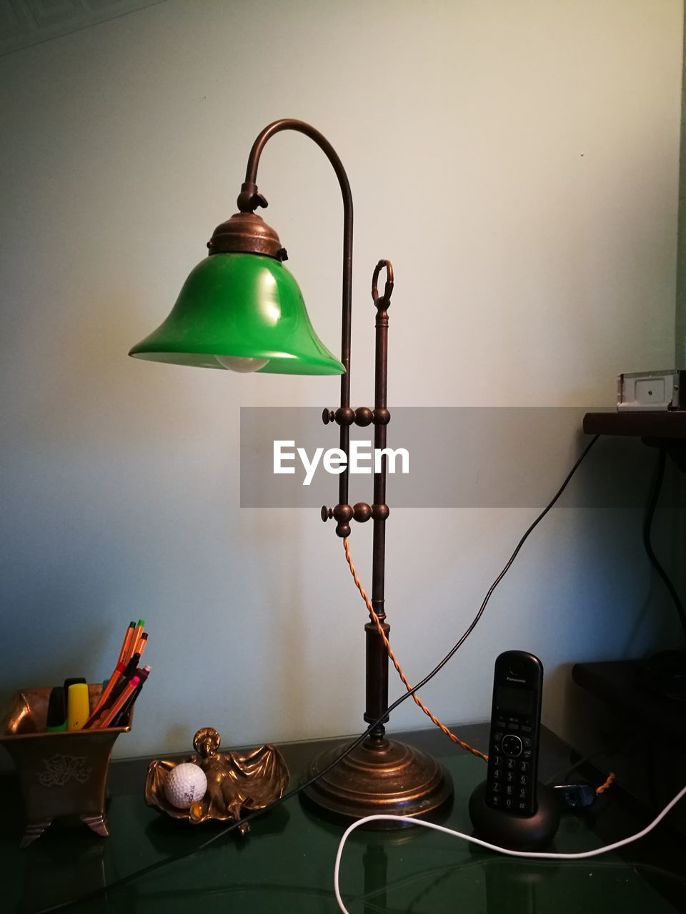 Electric lamp on table against wall at home