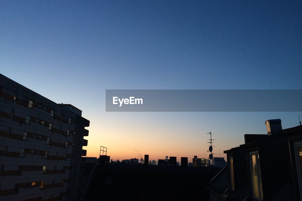 VIEW OF BUILDINGS AGAINST CLEAR SKY AT SUNSET