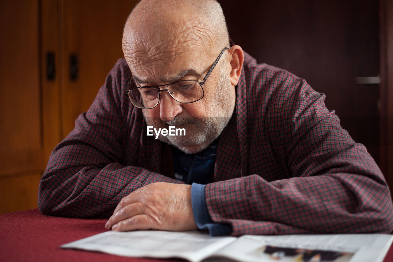 Close-up of man sitting on table at home