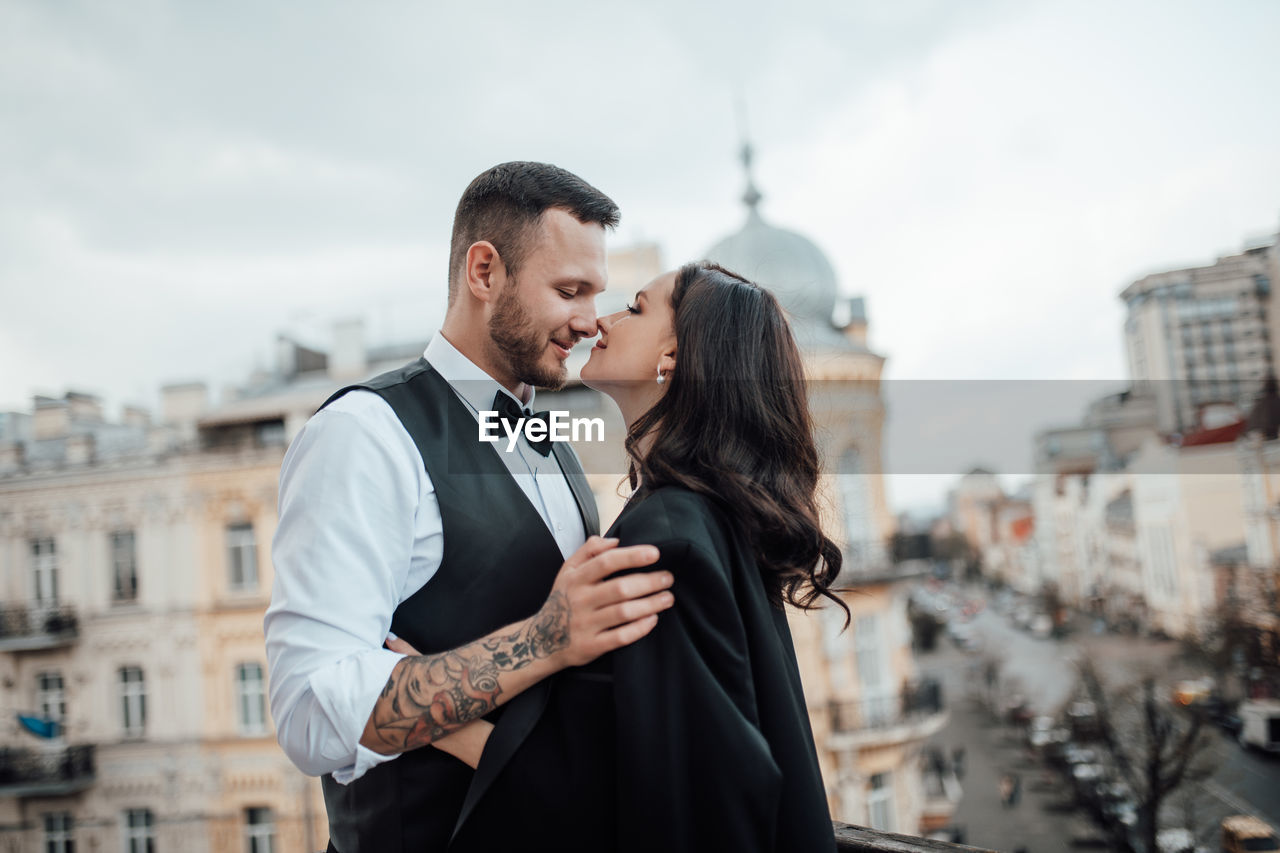 Young couple standing against city in background