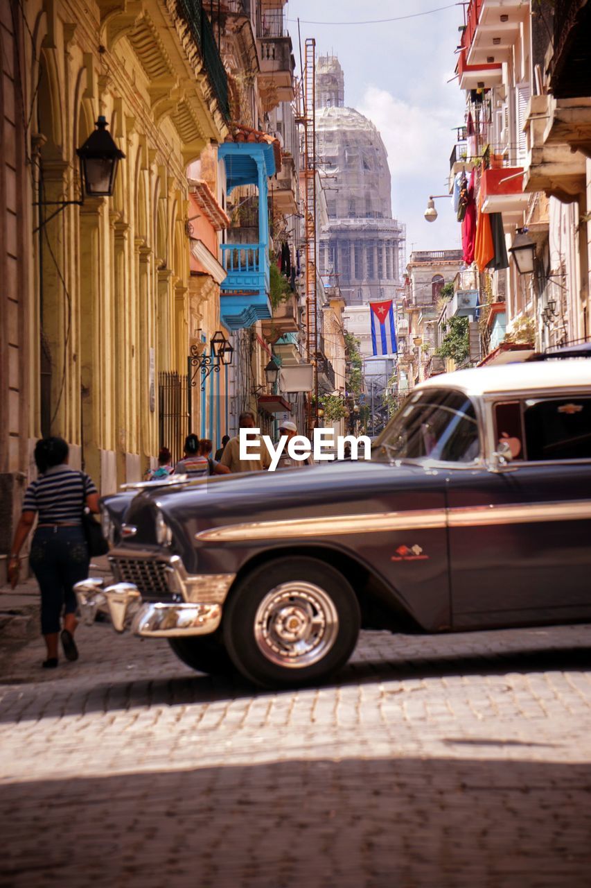 Vintage car on street against buildings in city