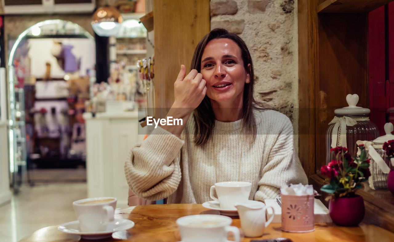 PORTRAIT OF SMILING WOMAN WITH COFFEE