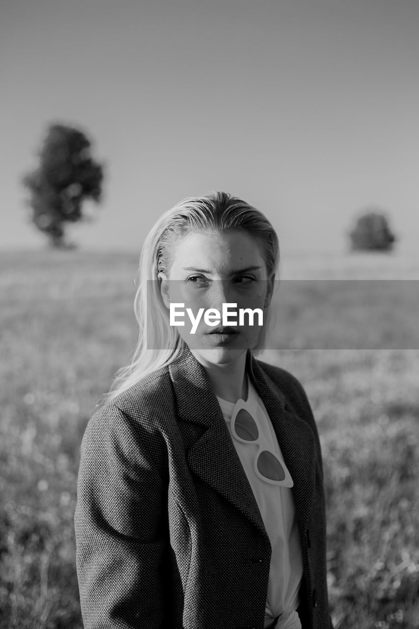 Portrait of young woman standing on field