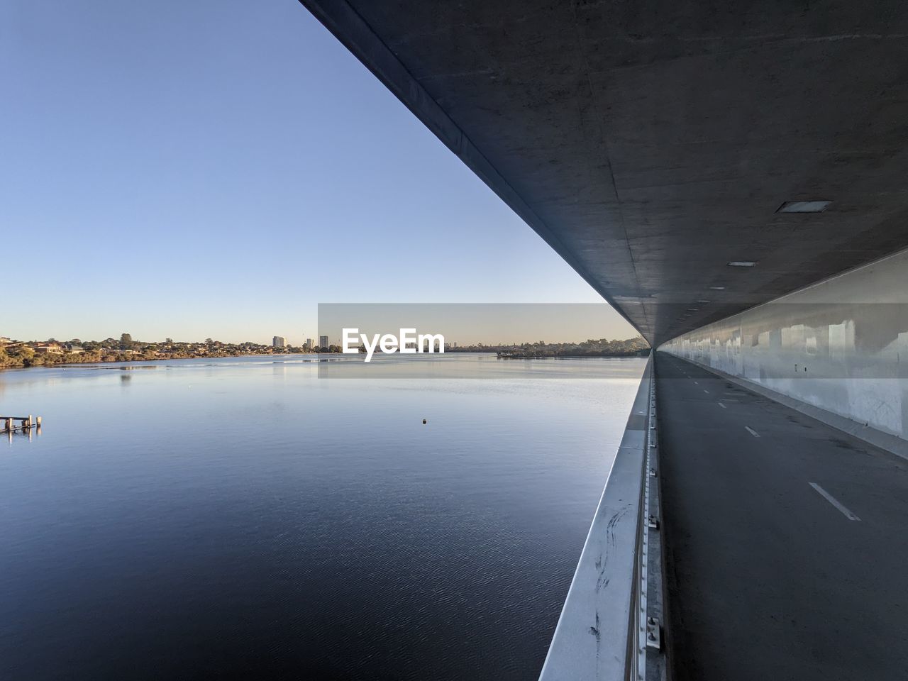 reflection, water, architecture, transportation, sky, built structure, nature, bridge, city, no people, horizon, sea, travel, outdoors, clear sky, travel destinations, day, blue, light, building exterior, scenics - nature, environment, vehicle, road, tranquility, landscape