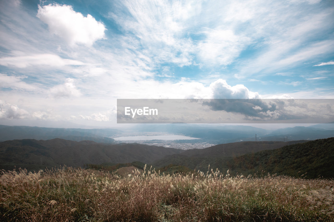 sky, nature, environment, landscape, cloud, horizon, scenics - nature, plant, mountain, beauty in nature, land, sunlight, grass, grassland, morning, tranquility, field, no people, meadow, rural area, tranquil scene, mountain range, rural scene, outdoors, plain, summer, blue, tree, wilderness, non-urban scene, natural environment, prairie, cloudscape, travel, plateau, day, fog, valley, forest, travel destinations, horizon over land, sun, idyllic, springtime, freshness, sunbeam