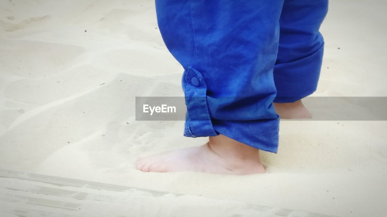 Low section of baby standing on beach
