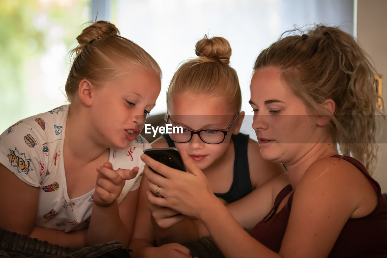 Woman with daughters using phone