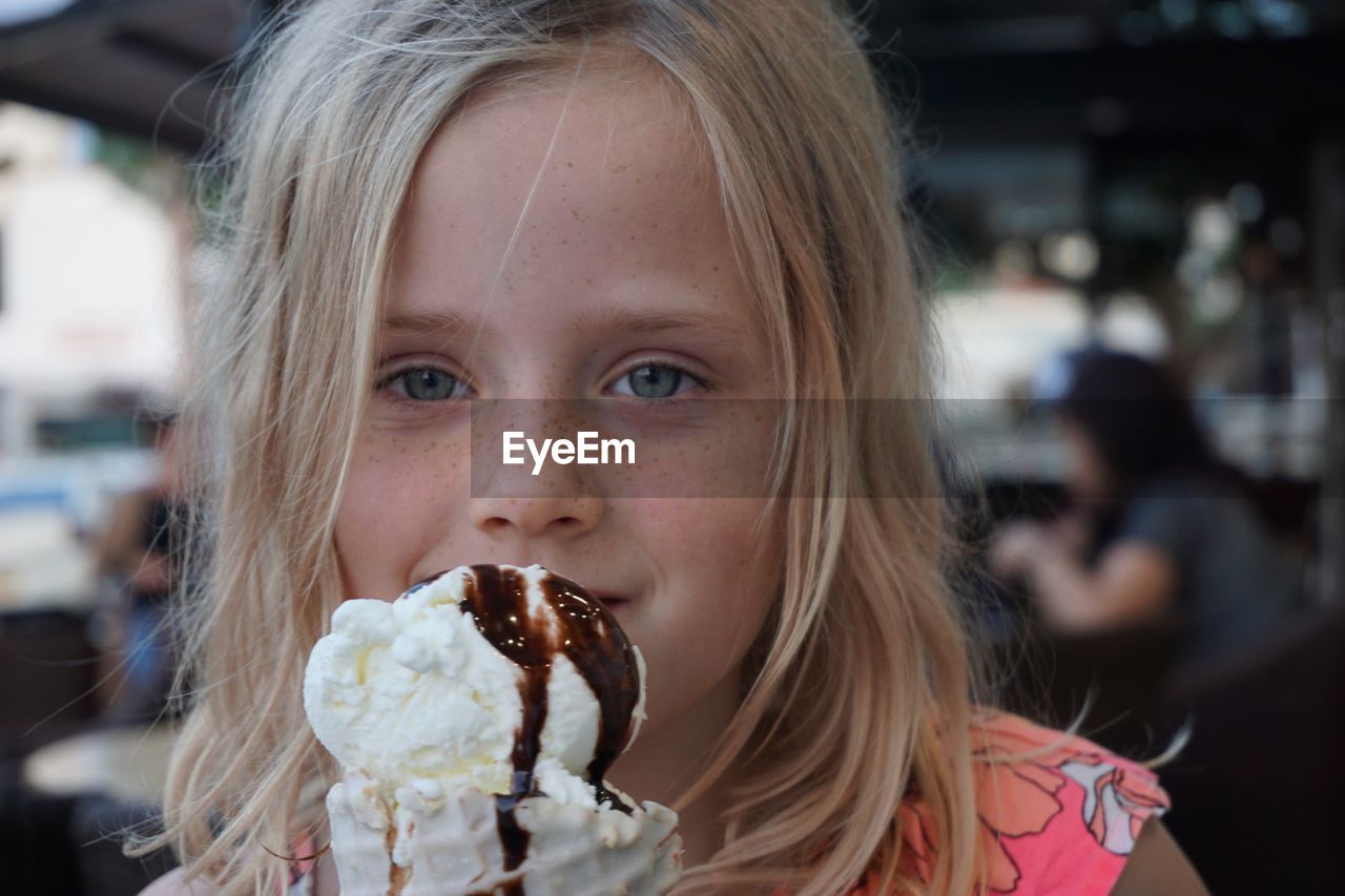 Close-up portrait of girl eating ice cream
