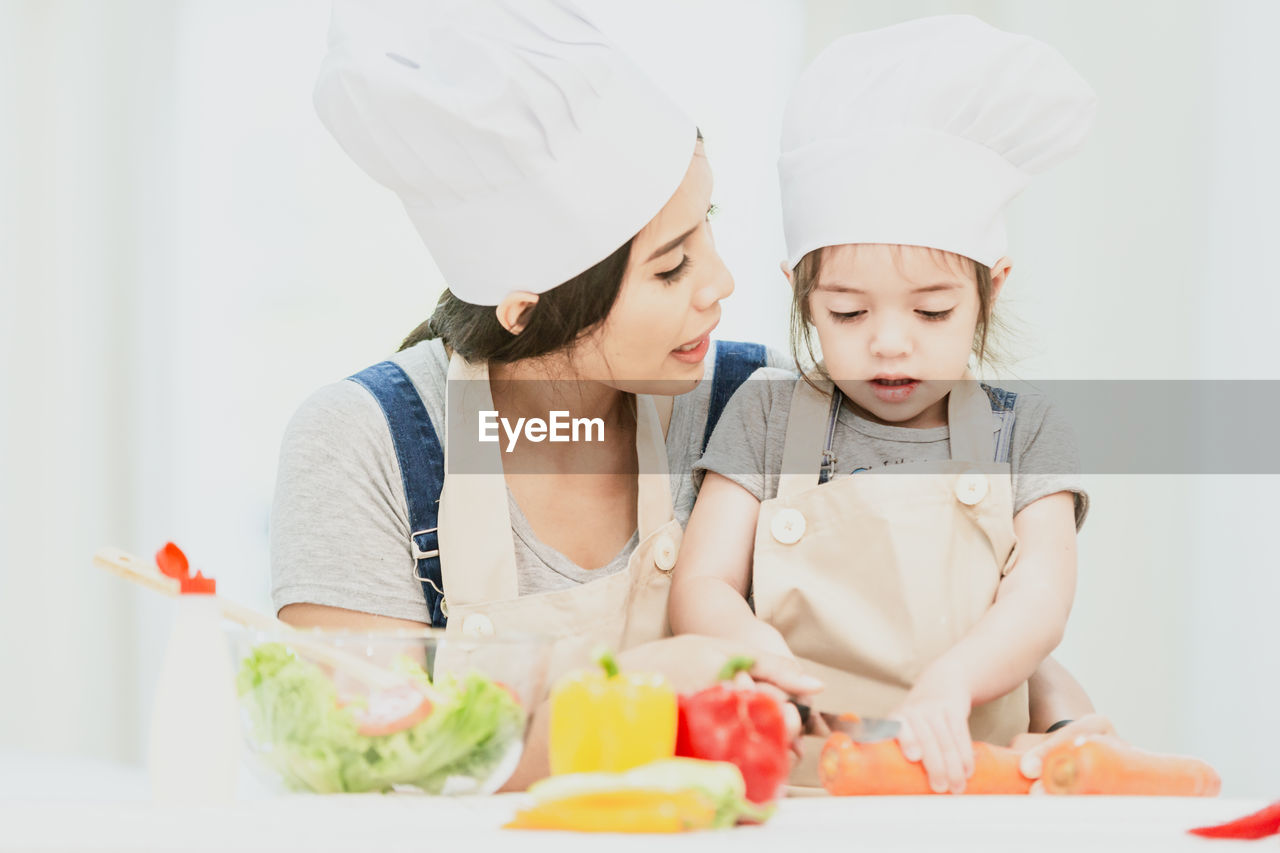 TWO PEOPLE PREPARING FOOD ON TABLE