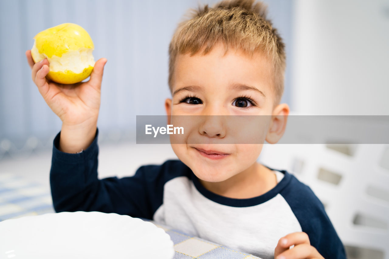 PORTRAIT OF BOY HOLDING ICE CREAM IN PLATE ON TABLE