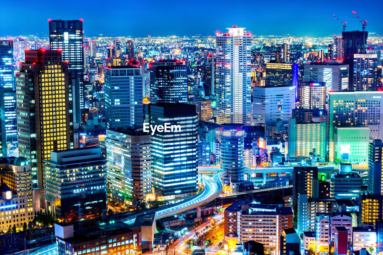 Illuminated cityscape against sky at night