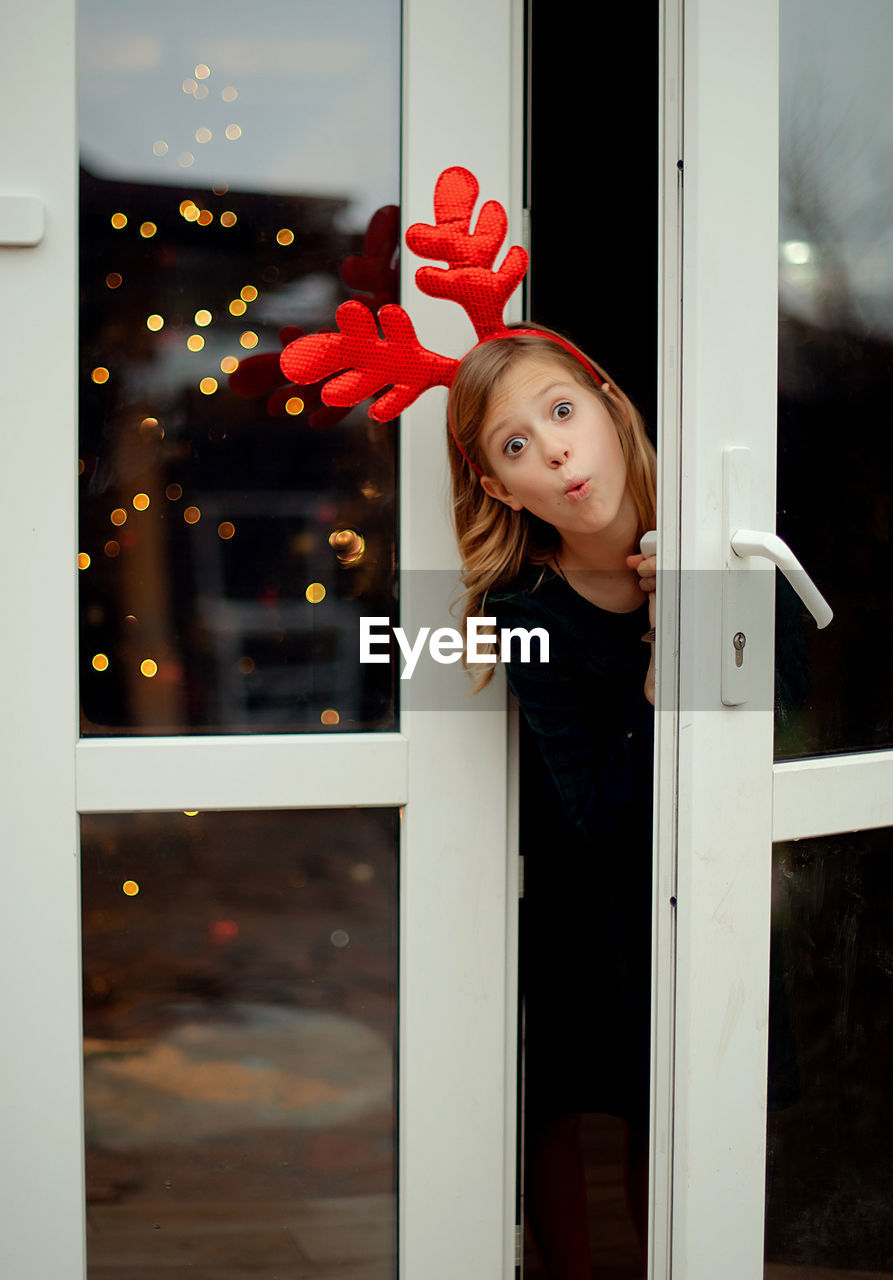 Portrait of girl looking through window