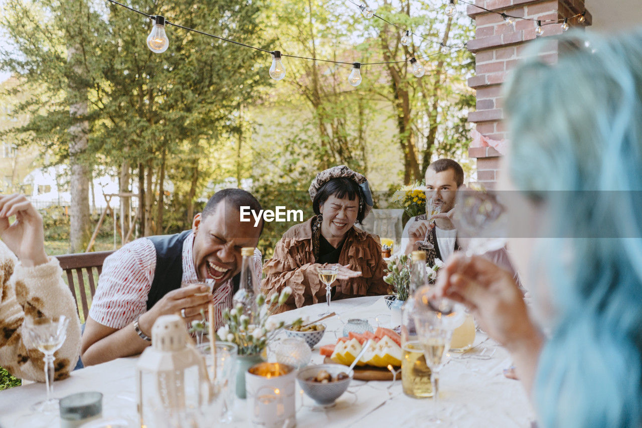 Friends of lgbtq community enjoying drinks during dinner party in back yard