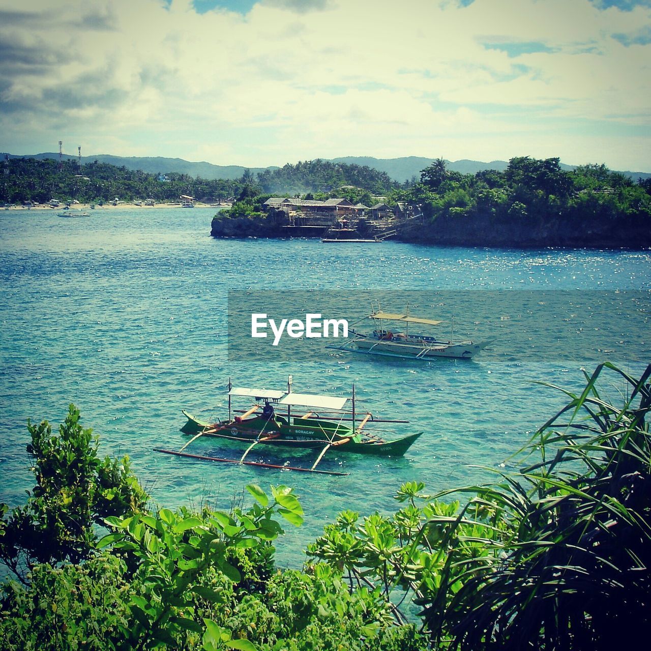 BOATS IN SEA WITH CITY IN BACKGROUND