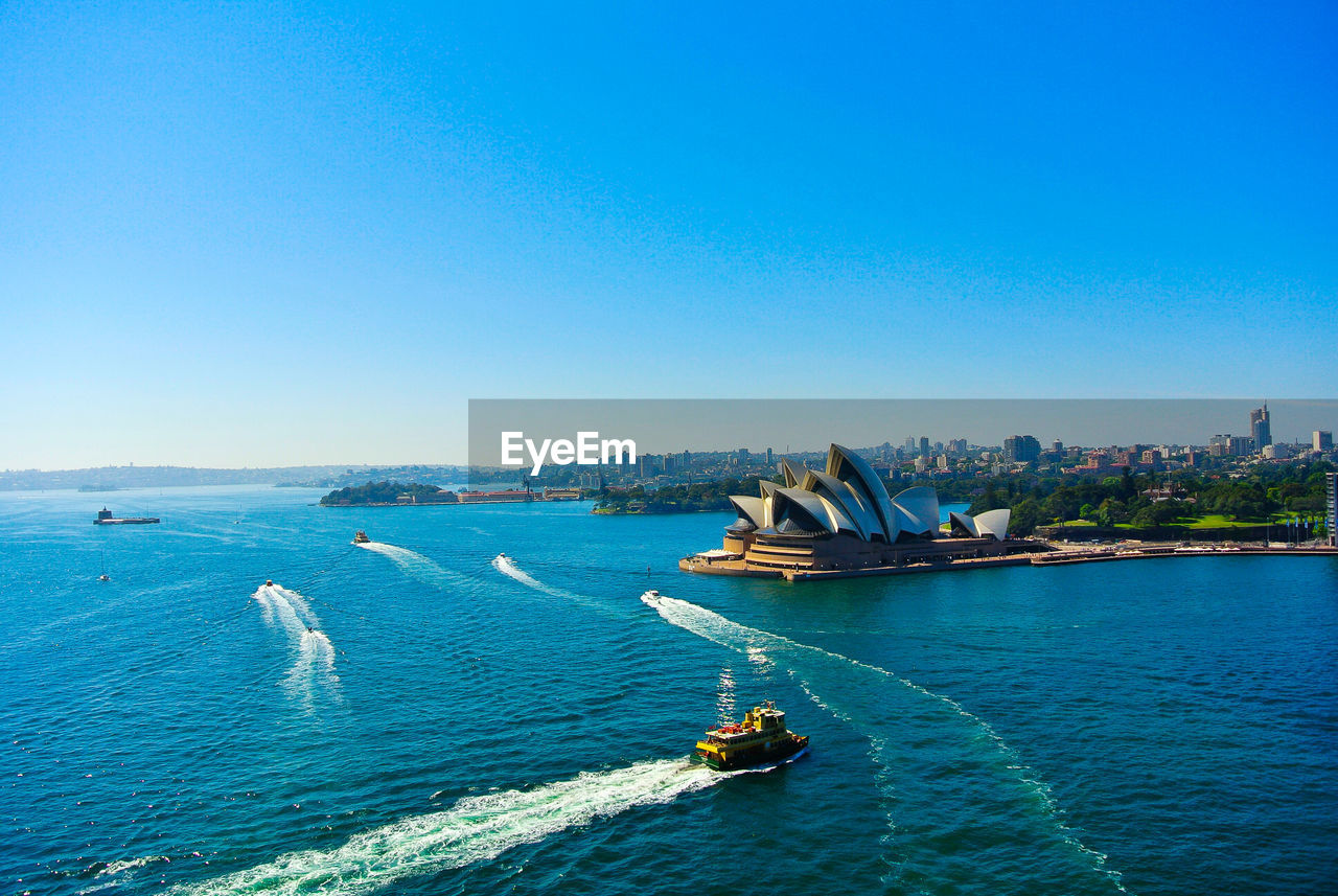 High angle view of cruise next to opera house against clear sky