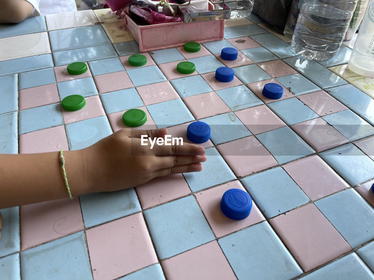 game, indoor games and sports, board game, hand, leisure activity, leisure games, sports, recreation, tabletop game, one person, relaxation, arts culture and entertainment, flooring, indoors, adult, high angle view, multi colored, lifestyles, creativity
