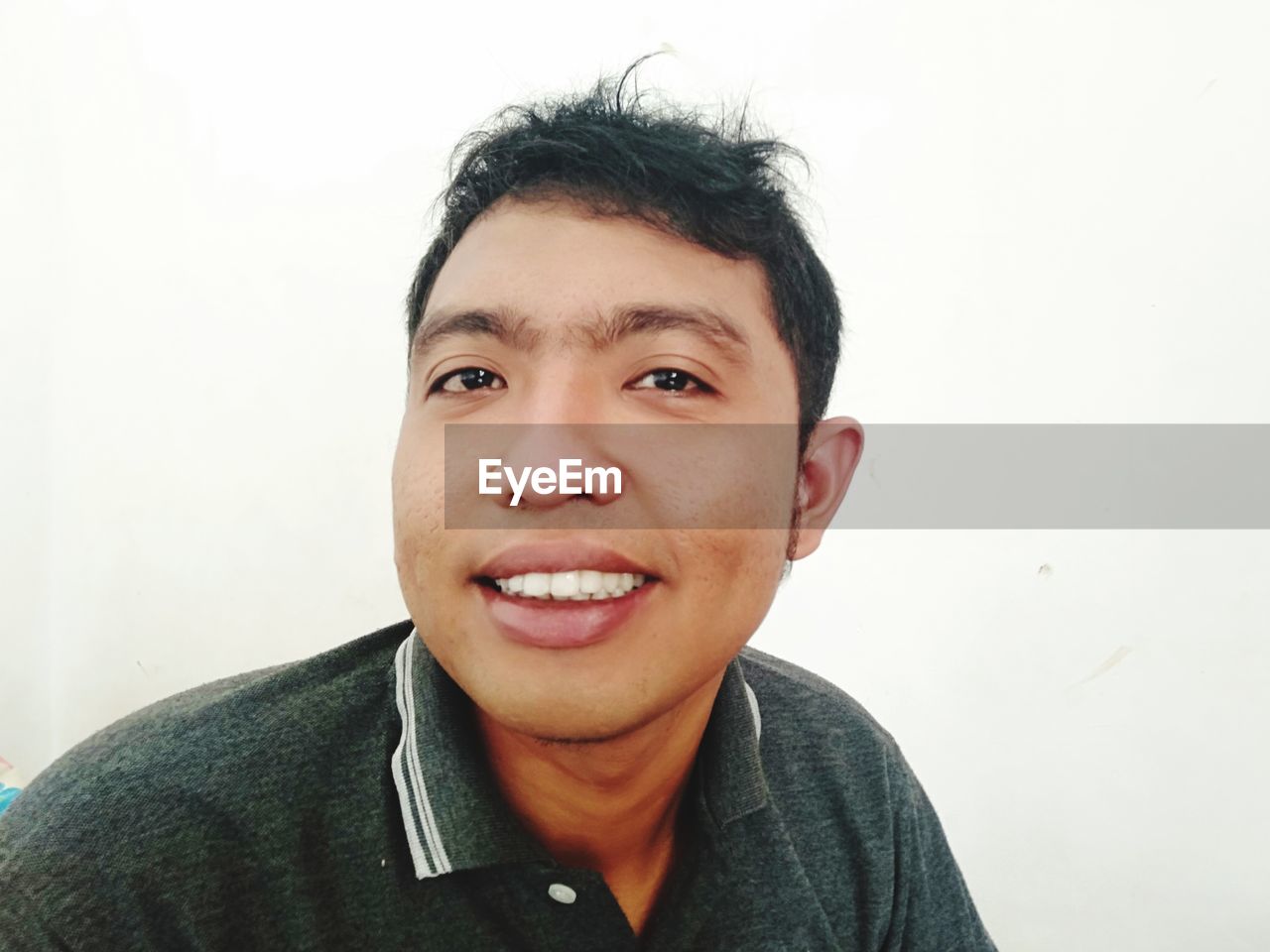 PORTRAIT OF HAPPY MAN AGAINST WHITE BACKGROUND