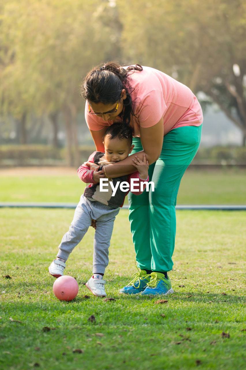 Mother playing with daughter in park