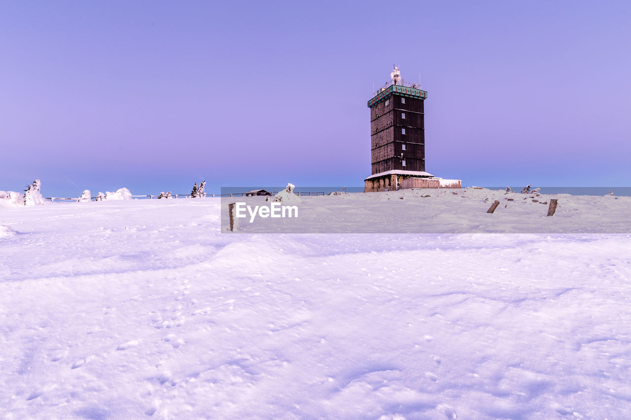 PEOPLE ON SNOW COVERED LAND AGAINST CLEAR SKY