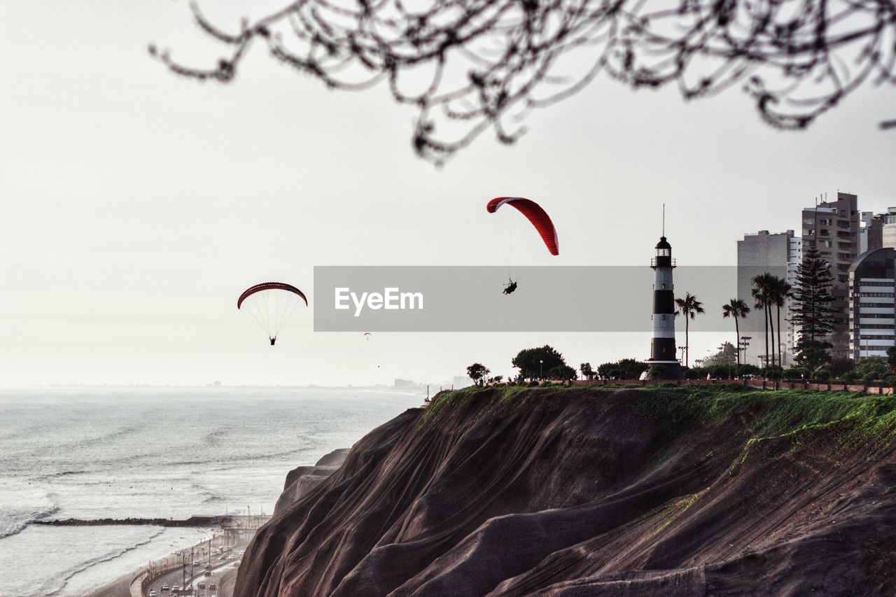 Scenic view of sea by buildings in city against sky