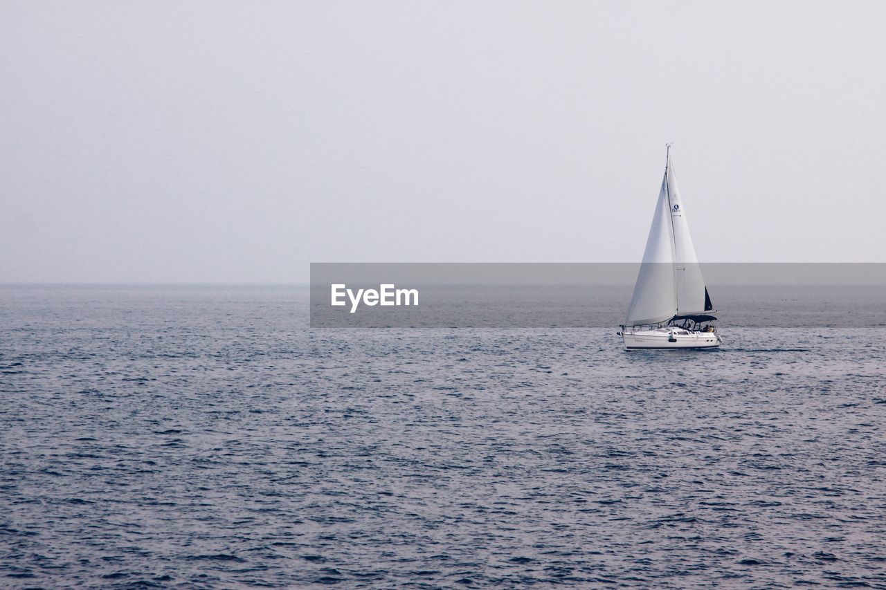 SAILBOATS SAILING IN SEA AGAINST SKY