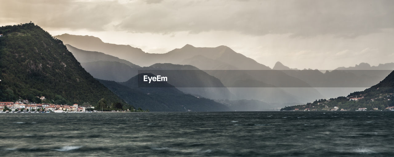 Scenic view of sea and mountains against sky