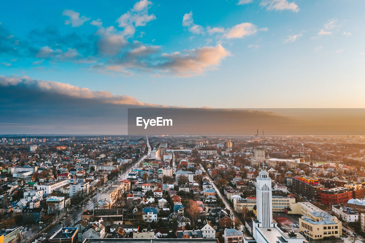 HIGH ANGLE VIEW OF CITY AGAINST CLOUDY SKY