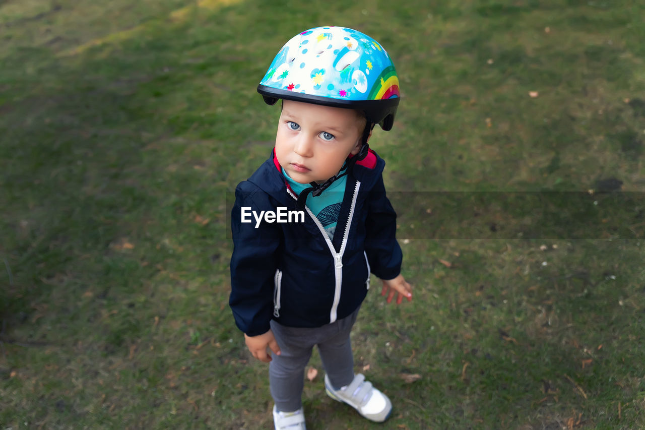 High angle view of cute boy standing on field