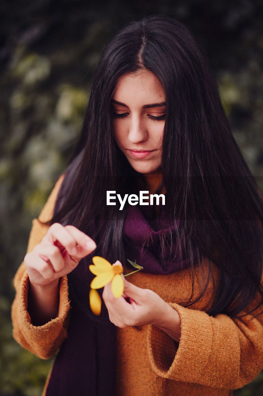 Beautiful young woman holding red flower