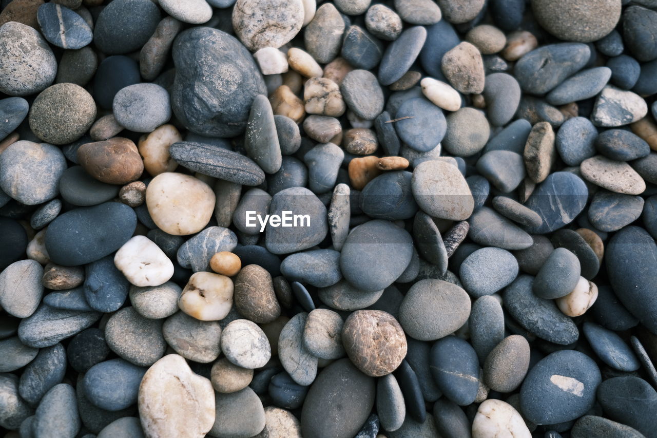 pebble, large group of objects, backgrounds, full frame, rock, abundance, gravel, stone, no people, nature, shape, high angle view, land, textured, beach, day, gray, directly above, outdoors, close-up, soil, pattern, tranquility, variation