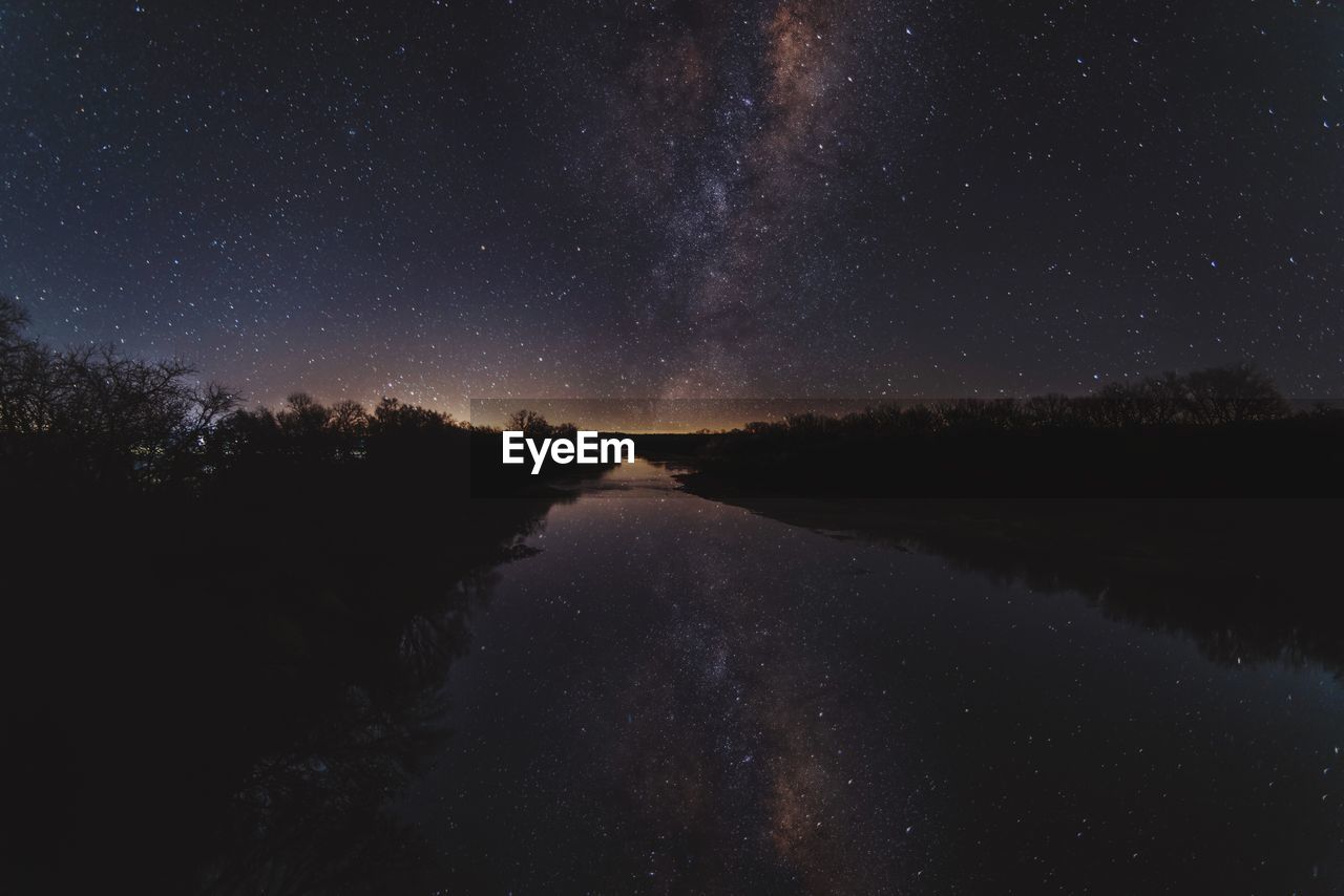 Scenic view of lake against sky at night