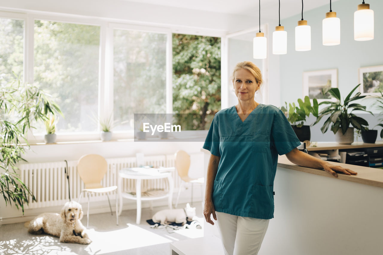 Portrait of confident female veterinarian at reception in veterinary clinic