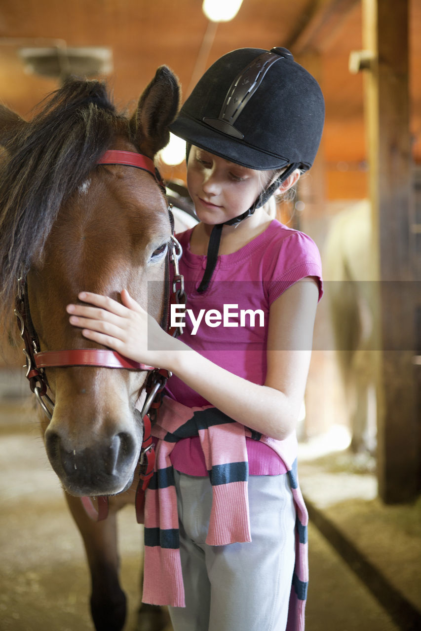 Girl with horse in stable