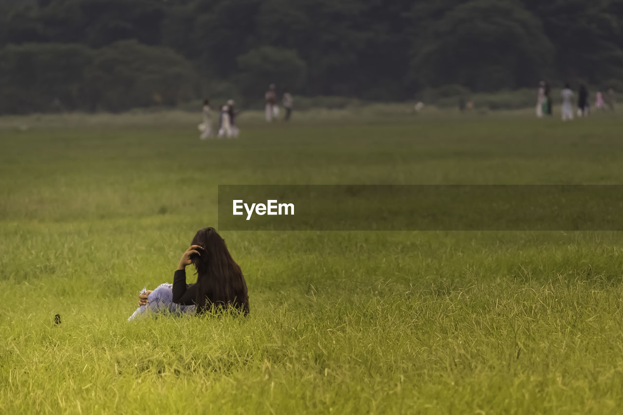 Woman sitting on grassy field