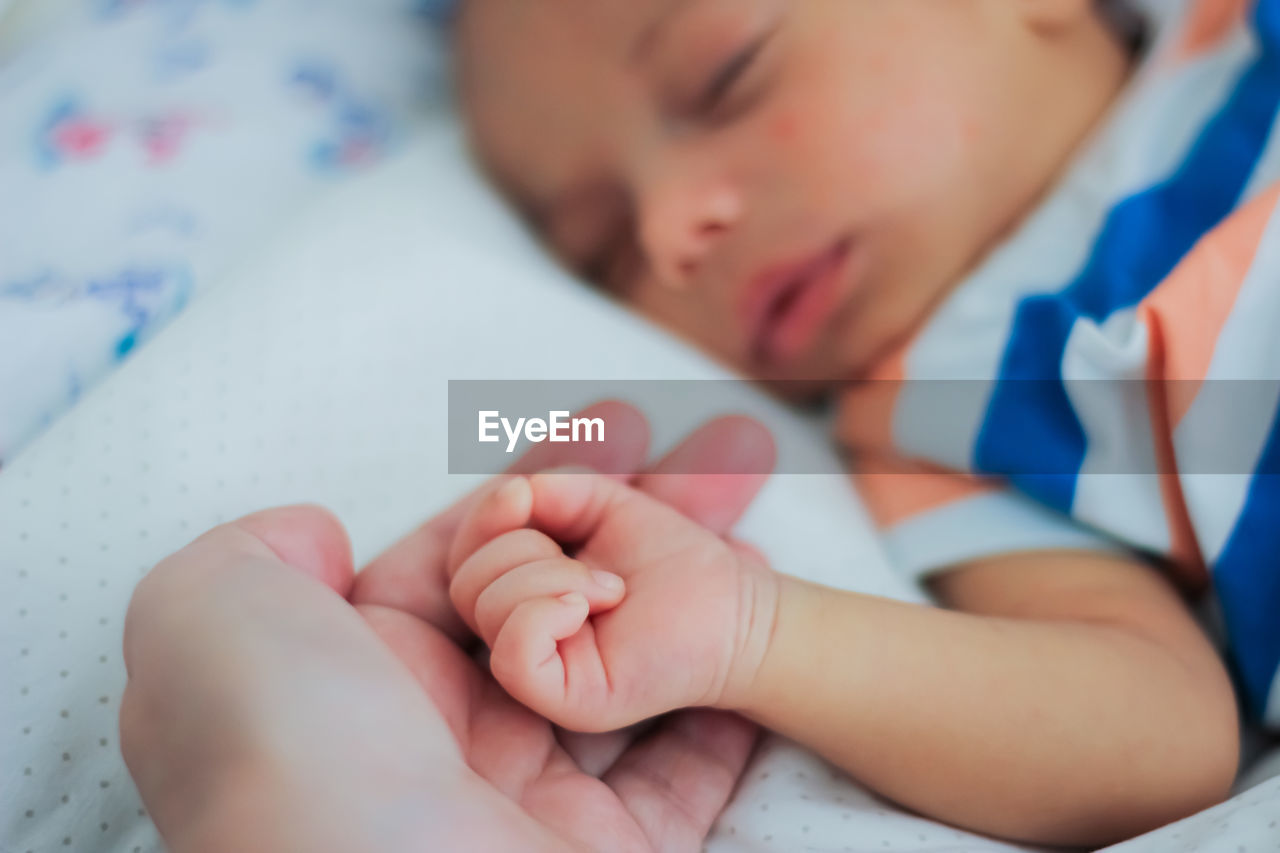 Close-up of mother and baby hand